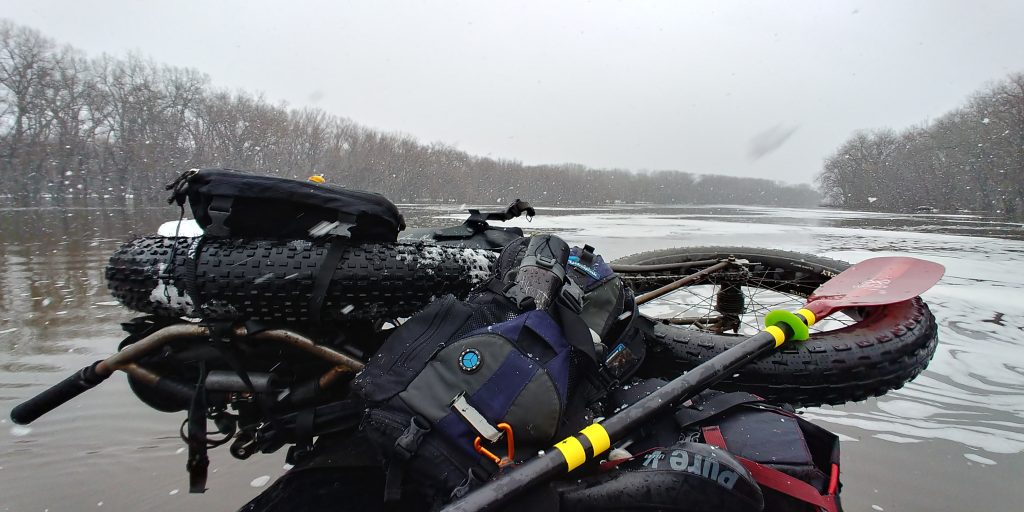 the history of fatbikes: This is one of my April 2019 work commutes, to the Science Museum of Minnesota, via the Mississippi River.  The Mississippi was flooded most of that spring season, and the current was relatively brisk.  So I took advantage of it on several occasions.  I was paddling an Alpacka Denali Llama with my single-speed Surly Moonlander strapped to the bow. 